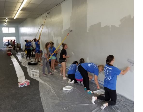 Photo of LCC team painting the walls of a hallway.